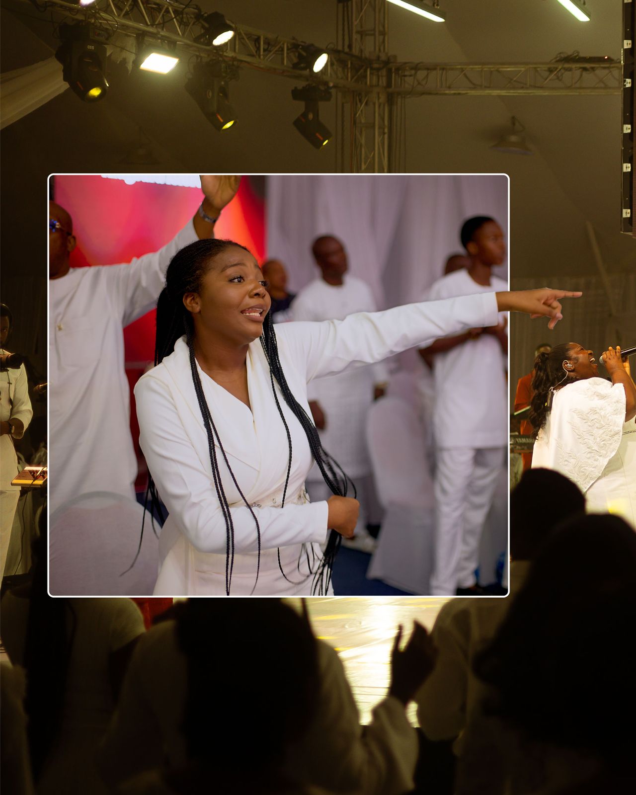 A worshipper in the congregation with her hand raised